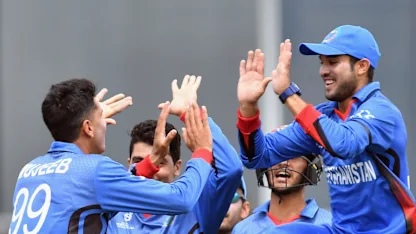Logo of Mujeeb Zadran of Afghanistan (L) is congratulated by team mates after dismissing Jakob Bhula of New Zealand