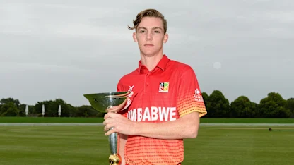 Logo of Zimbabwe U19 captain Liam Roche poses with the ICC Under 19 Cricket World Cup trophy.