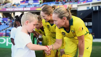Logo of Meg Lanning of Australia shakes hands with a young mascot during the ICC Women's World T20 2018 Semi-Final match between Windies and Australia at Sir Viv Richards Cricket Ground on November 22, 2018 in Antigua, Antigua and Barbuda.