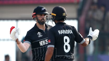 Daryl Mitchell (L) and Rachin Ravindra of New Zealand interact during the ICC Men's Cricket World Cup India 2023 match between India and New Zealand