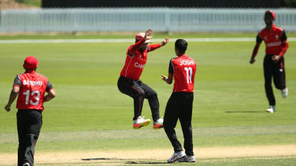 Arslan Khan (C) of Canada celebrates with team mate Rishiv Joshi after taking a catch