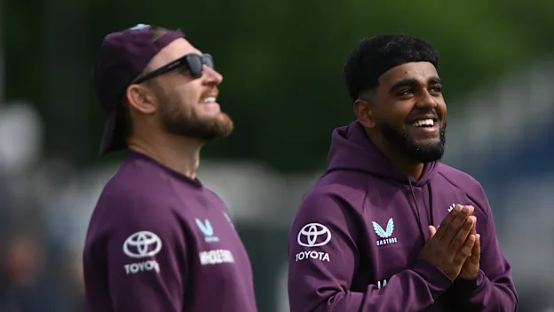 England bowler Rehan Ahmed and coach Brendon McCullum smile during nets