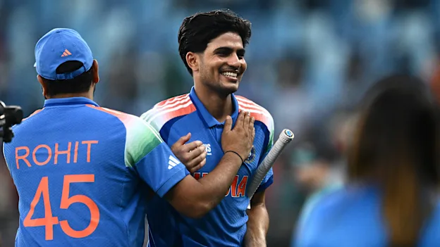India's Shubman Gill (R) is congratulated by his team captain Rohit Sharma at the end of the ICC Champions Trophy 