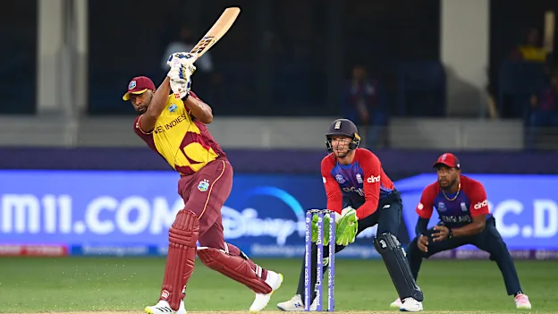 Kieron Pollard of West Indies plays a shot as Jos Buttler of England looks on during the ICC Men's T20 World Cup match between England and Windies at Dubai International Stadium on October 23, 2021 in Dubai, United Arab Emirates.