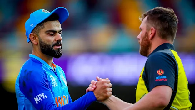 Australia's captain Aaron Finch (R) shakes hands with India's Virat Kohli after the Australia 2022 Twenty20 World Cup cricket warm-up match