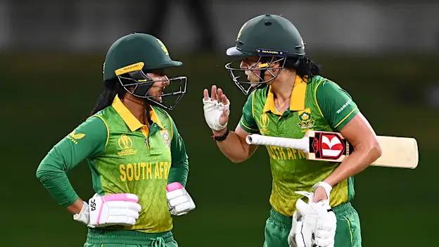 Marizanne Kapp (R) of South Africa gestures to teammate Trisha Chetty between overs during the 2022 ICC Women's Cricket World Cup match between South Africa and England at Bay Oval on March 14, 2022 in Tauranga, New Zealand.