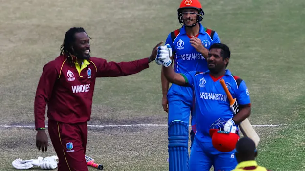 Afghan batsman M.Shahzad receives a consiliatory high five from Chris Gayle as he leaves the pitch after making 84 runs during the ICC Cricket World Cup Qualifier Trophy, Harare Sports Club March 25 2018 (©ICC).