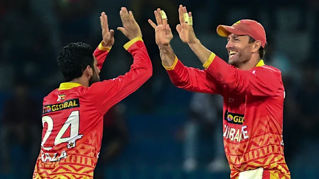 Zimbabwe's captain Craig Ervine (R) and Sikandar Raza celebrate after the dismissal of Sri Lanka's Dasun Shanaka during the second one-day international (ODI) cricket match between Sri Lanka and Zimbabwe at the R. Premadasa Stadium in Colombo