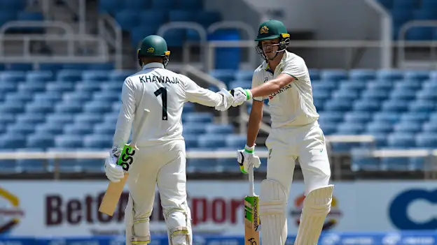 Usman Khawaja (L) and Sam Konstas (R) of Australia knock gloves during the first day of the 3rd Test between West Indies and Australia 
