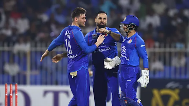 Mohammad Nabi (C) of Afghanistan celebrates with Rahmanullah Gurbaz (R) of Afghanistan and Noor Ahmad Lakanwal (L) of Afghanistan