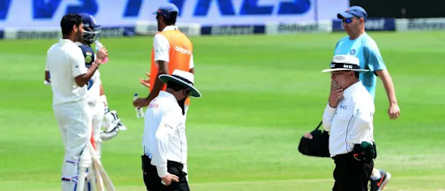 Umpires discuss the state of the pitch