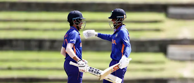 Raj Bawa of India celebrates his century with team mate Angkrish Raghuvanshi during the ICC U19 Men's Cricket World Cup match between India and Uganda at Brian Lara Cricket Academy on January 22, 2022 in Tarouba, Trinidad And Tobago.