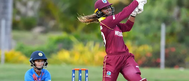 Hayley Matthews (R) of Windies hits 6 as Tanya Bhatia (L) of India watch during a warm-up match at Coolidge Cricket Ground on November 4, 2018 in Coolidge, Antigua and Barbuda.