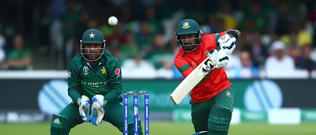 Liton Das of Bangladesh plays a shot as Sarfaraz Ahmed of Pakistan looks on during the Group Stage match of the ICC Cricket World Cup 2019 between Pakistan and Bangladesh at Lords on July 05, 2019 in London, England.