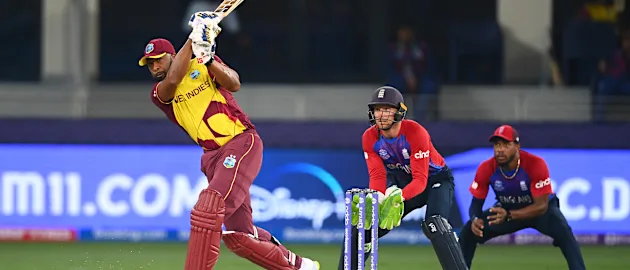 Kieron Pollard of West Indies plays a shot as Jos Buttler of England looks on during the ICC Men's T20 World Cup match between England and Windies at Dubai International Stadium on October 23, 2021 in Dubai, United Arab Emirates.
