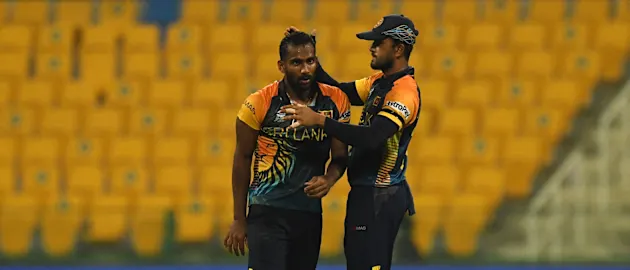 Chamika Karunaratne (L) is congratulated by his teammate Dinesh Chandimal.