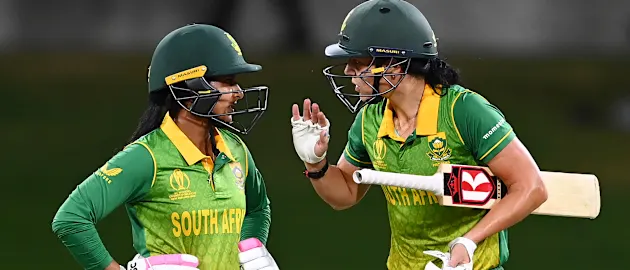 Marizanne Kapp (R) of South Africa gestures to teammate Trisha Chetty between overs during the 2022 ICC Women's Cricket World Cup match between South Africa and England at Bay Oval on March 14, 2022 in Tauranga, New Zealand.