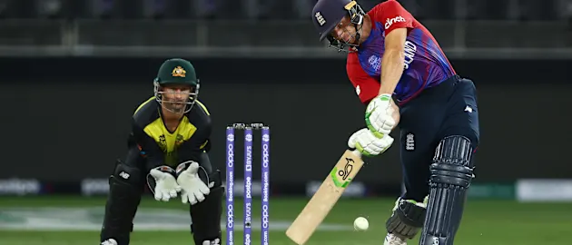 Jos Buttler of England plays a shot as Matthew Wade of Australia looks on during the ICC Men's T20 World Cup match between Australia and England at Dubai International Stadium on October 30, 2021 in Dubai, United Arab Emirates.