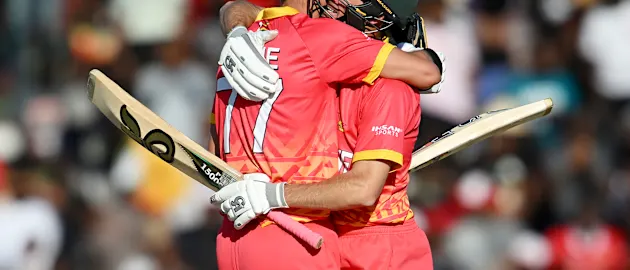 Craig Ervine of Zimbabwe celebrates reaching his century with teammate Sean Williams during the ICC Men's Cricket World Cup Qualifier Zimbabwe 2023 match between Zimbabwe and Nepal at Harare Sports Club on June 18, 2023 in Harare, Zimbabwe.