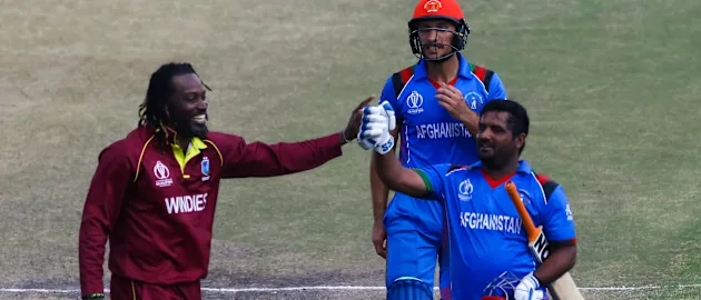 Afghan batsman M.Shahzad receives a consiliatory high five from Chris Gayle as he leaves the pitch after making 84 runs during the ICC Cricket World Cup Qualifier Trophy, Harare Sports Club March 25 2018 (©ICC).