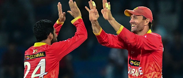 Zimbabwe's captain Craig Ervine (R) and Sikandar Raza celebrate after the dismissal of Sri Lanka's Dasun Shanaka during the second one-day international (ODI) cricket match between Sri Lanka and Zimbabwe at the R. Premadasa Stadium in Colombo