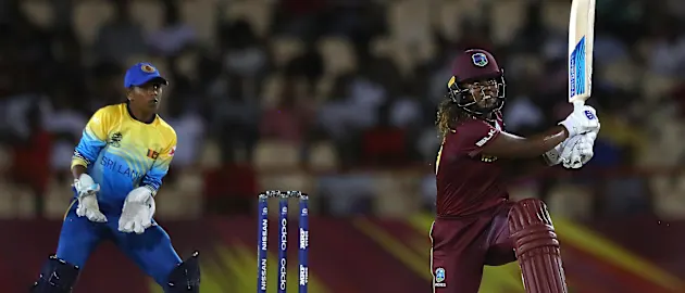Hayley Matthews of Windies hits the ball towards the boundary, as Dilani Manodara of Sri Lanka looks on during the ICC Women's World T20 2018 match between Windies and Sri Lanka at Darren Sammy Cricket Ground on November 16, 2018