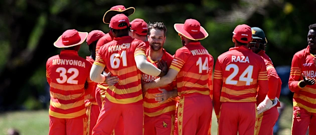 Zimbabwe's players congratulate Ryan Burl (C) after he took five wickets during the third one-day international (ODI) cricket match between Australia and Zimbabwe at the Riverway Stadium in Townsville on September 3, 2022.