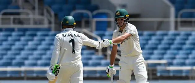 Usman Khawaja (L) and Sam Konstas (R) of Australia knock gloves during the first day of the 3rd Test between West Indies and Australia 