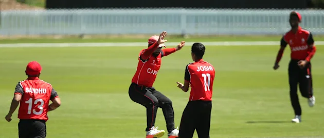 Arslan Khan (C) of Canada celebrates with team mate Rishiv Joshi after taking a catch
