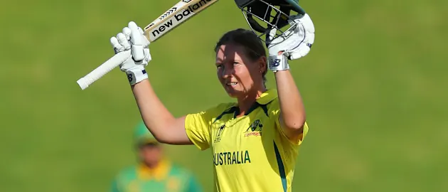 Meg Lanning of Australia raises her bat after scoring a century during the 2022 ICC Women's Cricket World Cup match between South Africa and Australia at Basin Reserve on March 22, 2022 in Wellington, New Zealand.
