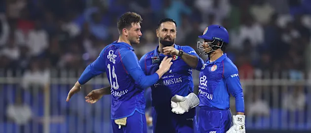 Mohammad Nabi (C) of Afghanistan celebrates with Rahmanullah Gurbaz (R) of Afghanistan and Noor Ahmad Lakanwal (L) of Afghanistan
