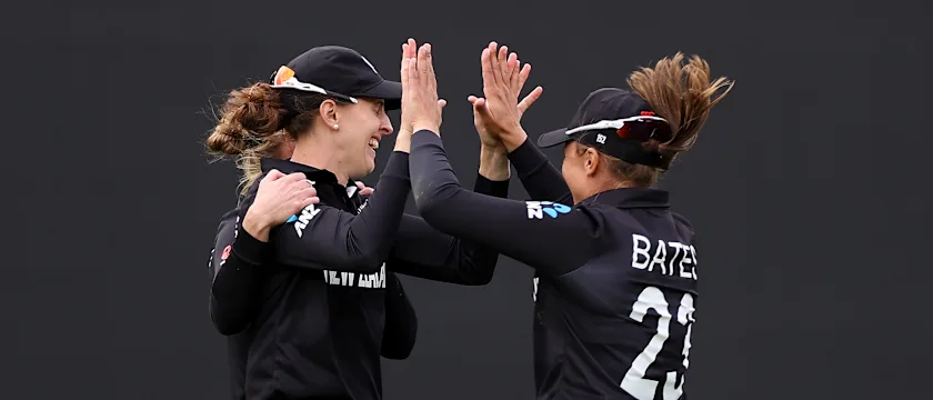Amy Satterthwaite (L) of New Zealand celebrates with Suzie Bates after taking the wicket of Amy Jones of England during the 2022 ICC Women's Cricket World Cup match between New Zealand and England at Eden Park on March 20, 2022 in Auckland, New Zealand.