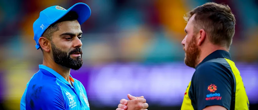Australia's captain Aaron Finch (R) shakes hands with India's Virat Kohli after the Australia 2022 Twenty20 World Cup cricket warm-up match