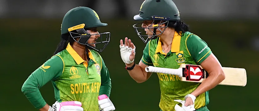 Marizanne Kapp (R) of South Africa gestures to teammate Trisha Chetty between overs during the 2022 ICC Women's Cricket World Cup match between South Africa and England at Bay Oval on March 14, 2022 in Tauranga, New Zealand.