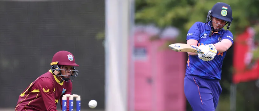 Yastika Bhatia from India smashes a boundary as West Indies wicket keeper Shemaine Campbelle looks on during the 2022 ICC Women's Cricket World Cup warm up match between West Indies and India.