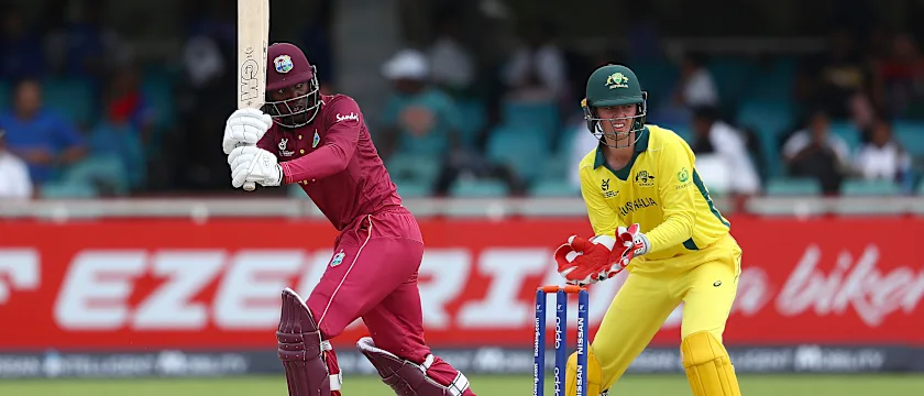 Nyeem Young of West Indies hits the ball towards the boundary, as Patrick Rowe of Australia looks on during the ICC U19 Cricket World Cup Group B match between Australia and West Indies at De Beers Diamond Oval on January 18, 2020.