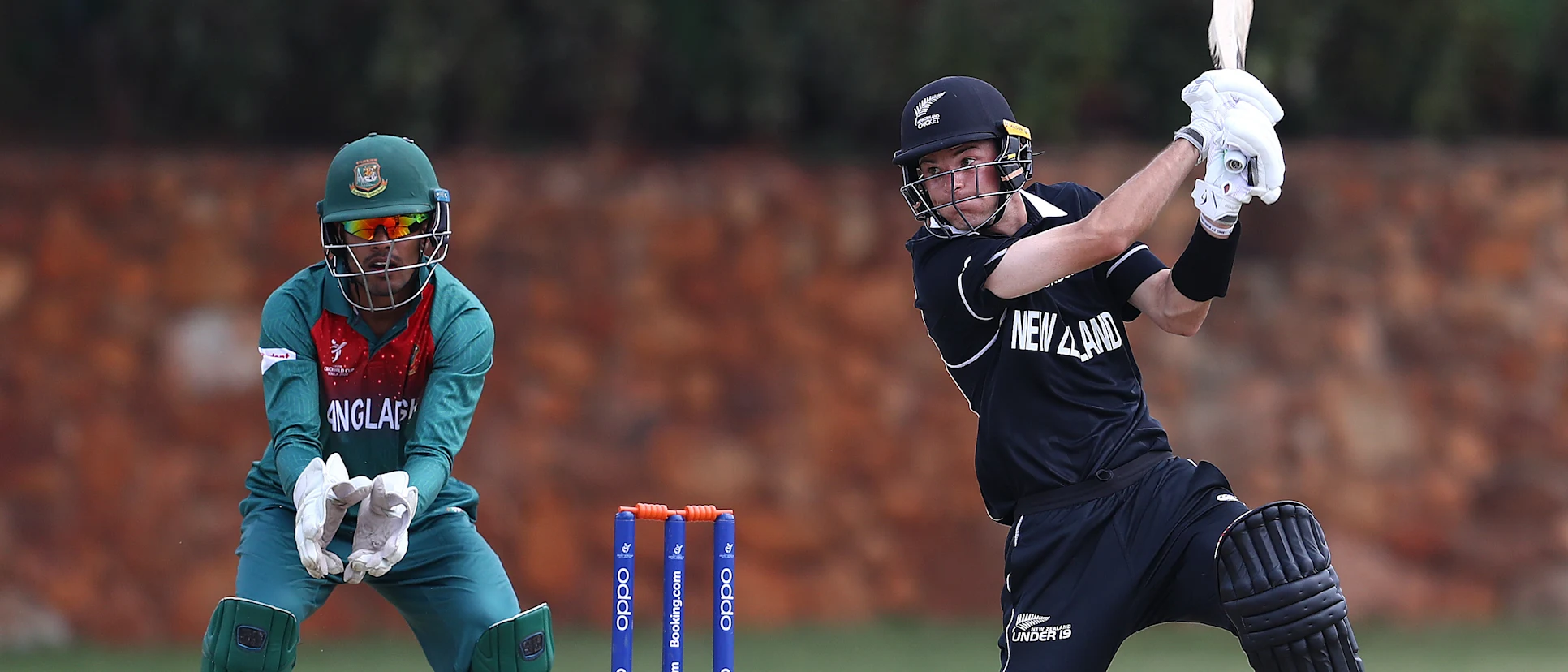 Jesse Tashkoff of New Zealand hits the ball towards the boundary, as Mohammad Akbar Ali of Bangladesh looks on during the ICC U19 Cricket World Cup warm up match between New Zealand and Bangladesh at St John's College on January 15, 2020.
