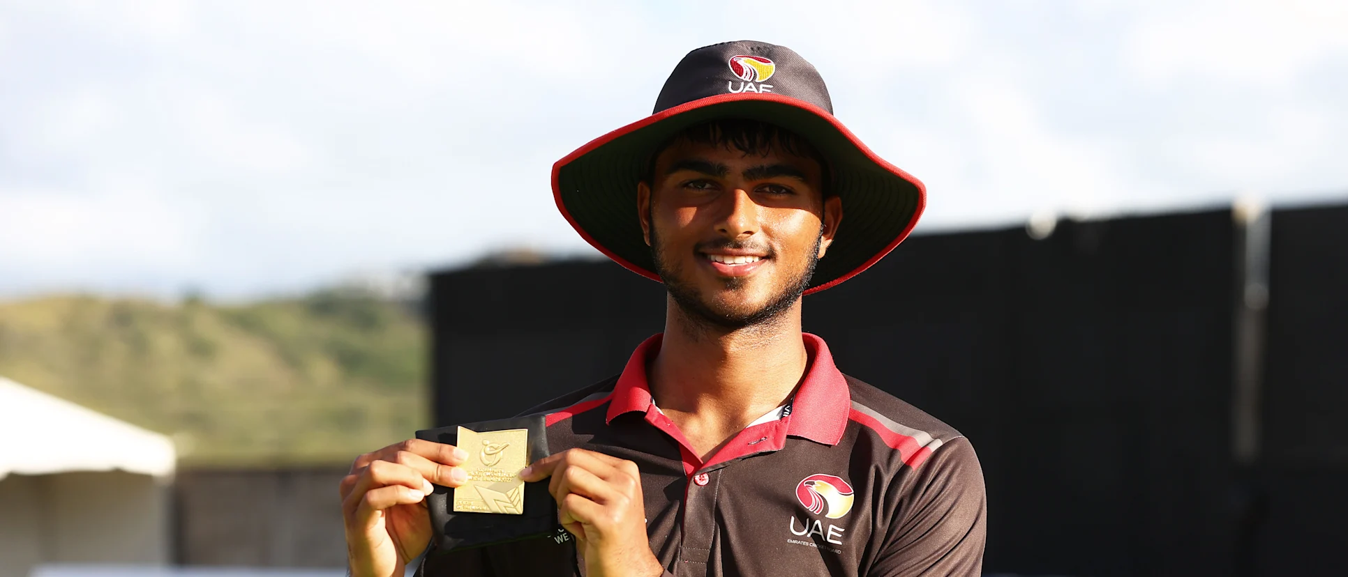 Logo of Ali Naseer of United Arab Emirates poses after being named Player of the Match following the ICC U19 Men's Cricket World Cup match between Canada and the United Arab Emirates at Conaree Sports Club on January 15, 2022 in Basseterre, Saint Kitts and Nevis.