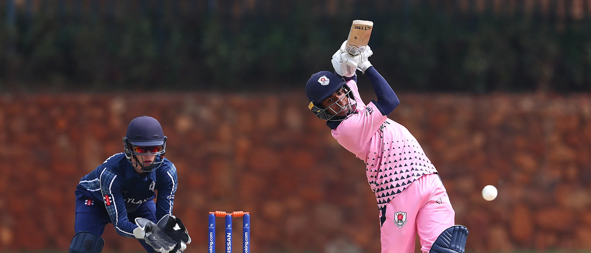 Logo of Debashish Sahoo of Japan hits the ball towards the boundary, as Tom Mackintosh of Scotland looks on during the ICC U19 Cricket World Cup warm up match between Scotland and Japan at St John's College on January 13, 2020 in Johannesburg, South Africa.