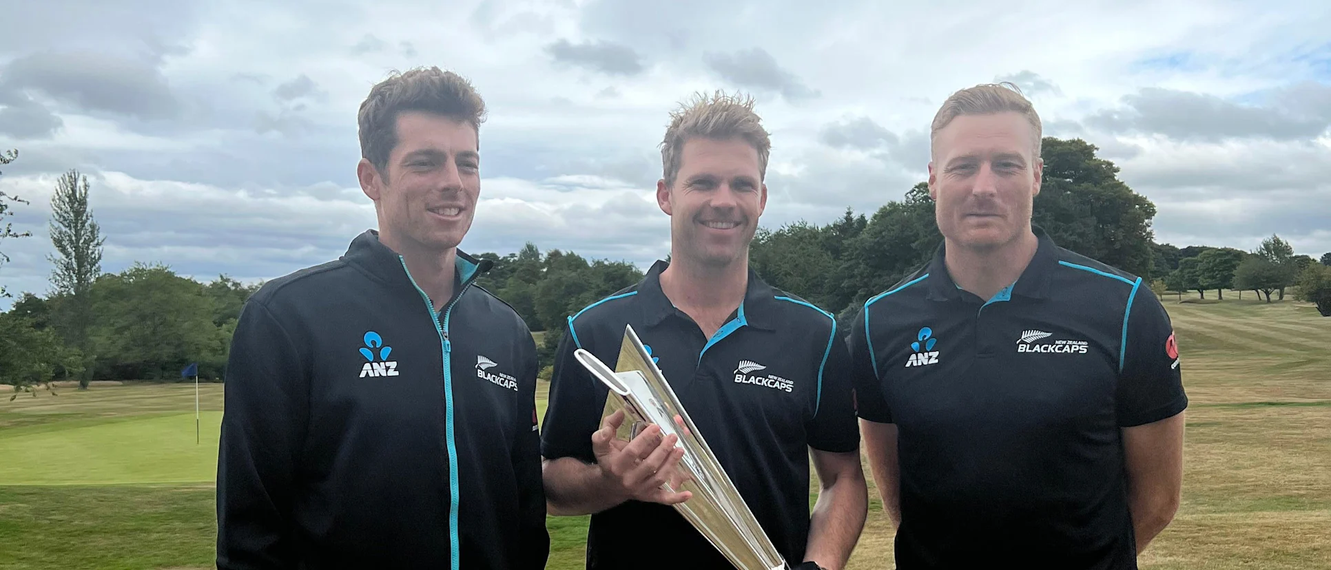 Logo of New Zealand's Mitchell Santner, Lockie Ferguson and Martin Guptill with the T20 World Cup trophy in Scotland