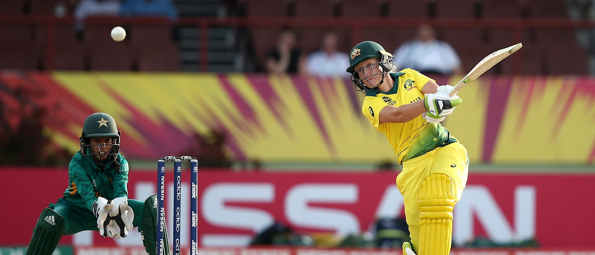Logo of Alyssa Healy of Australia bats with Sidra Nawaz, wicket keeper of Pakistan looking on during the ICC Women's World T20 2018 match between Australia and Pakistan at Guyana National Stadium on November 9, 2018 in Providence, Guyana.