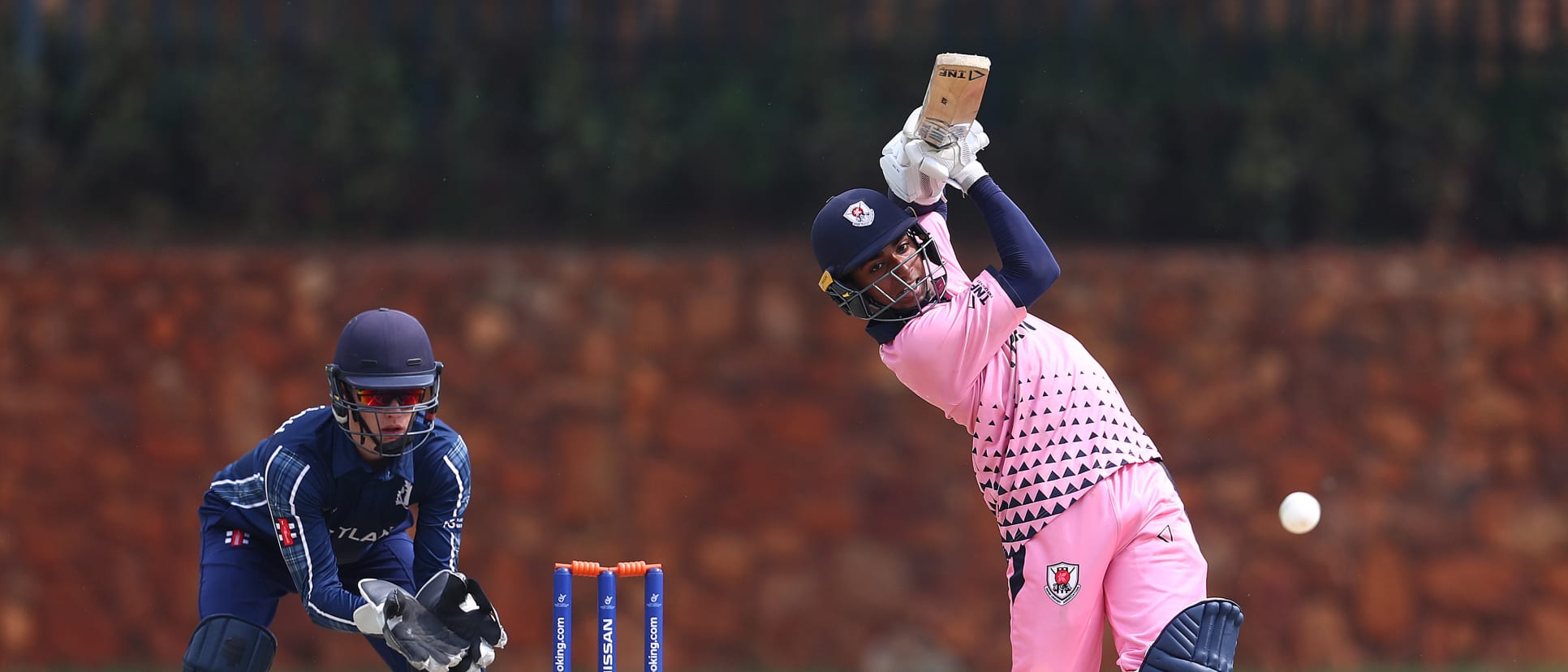 Debashish Sahoo of Japan hits the ball towards the boundary, as Tom Mackintosh of Scotland looks on during the ICC U19 Cricket World Cup warm up match between Scotland and Japan at St John's College on January 13, 2020 in Johannesburg, South Africa.