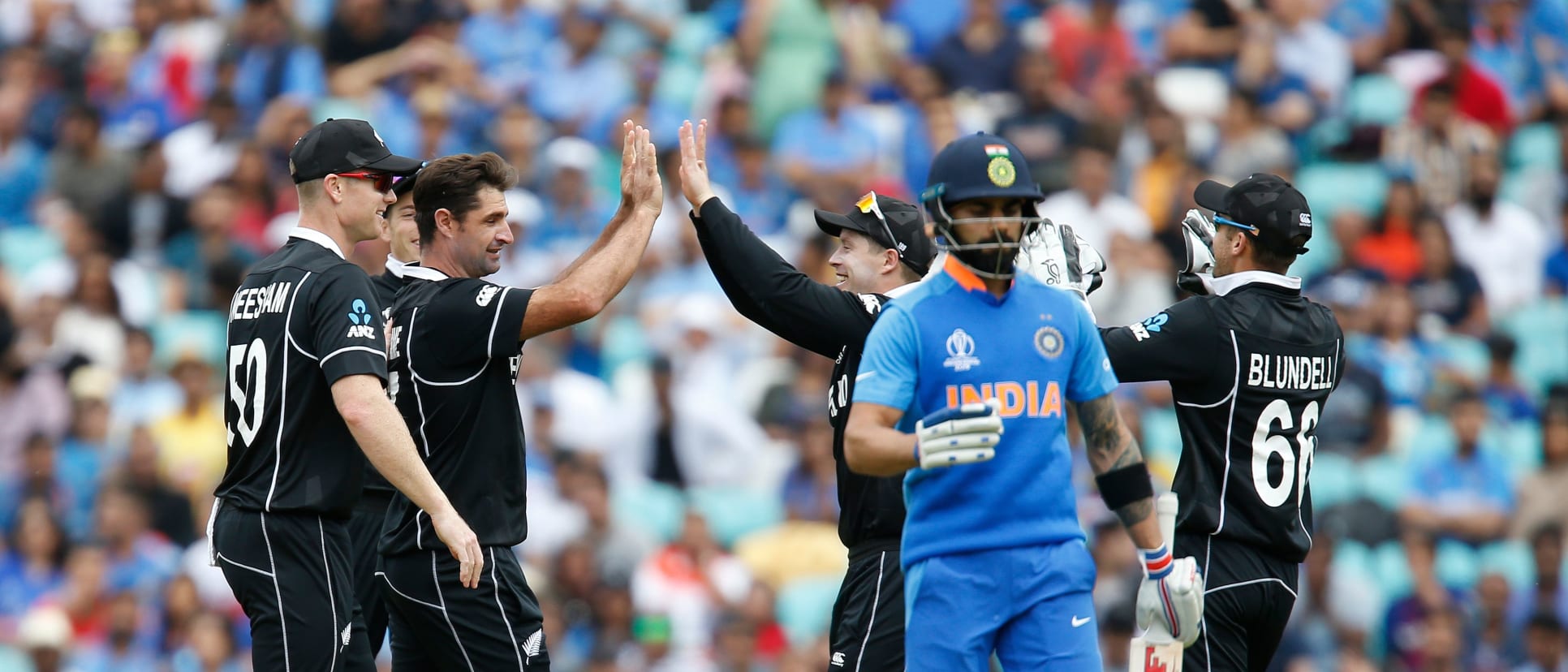 New Zealand's Colin de Grandhomme (2L) celebrates bowling India's Captain Virat Kohli (2R) for 18 runs during the 2019 Cricket World Cup warm up match between India and New Zealand at The Oval in London on May 25, 2019.
