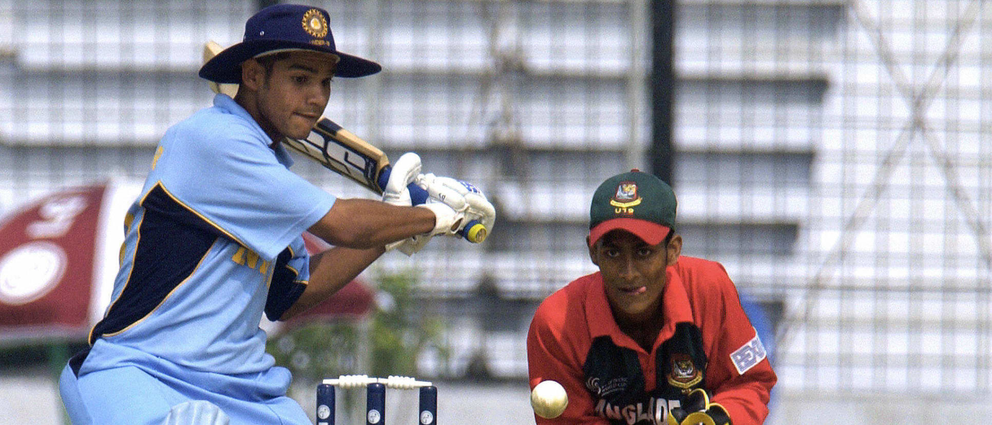 Indian U19 cricketer Shikhar Dhawan (L) prepares to play a stroke as Bangladeshi wicketkeeper Dhiman Ghosh looks on during a match of The Under-19 World Cup Cricket tournament between Bangladesh and India, 20 February 2004.