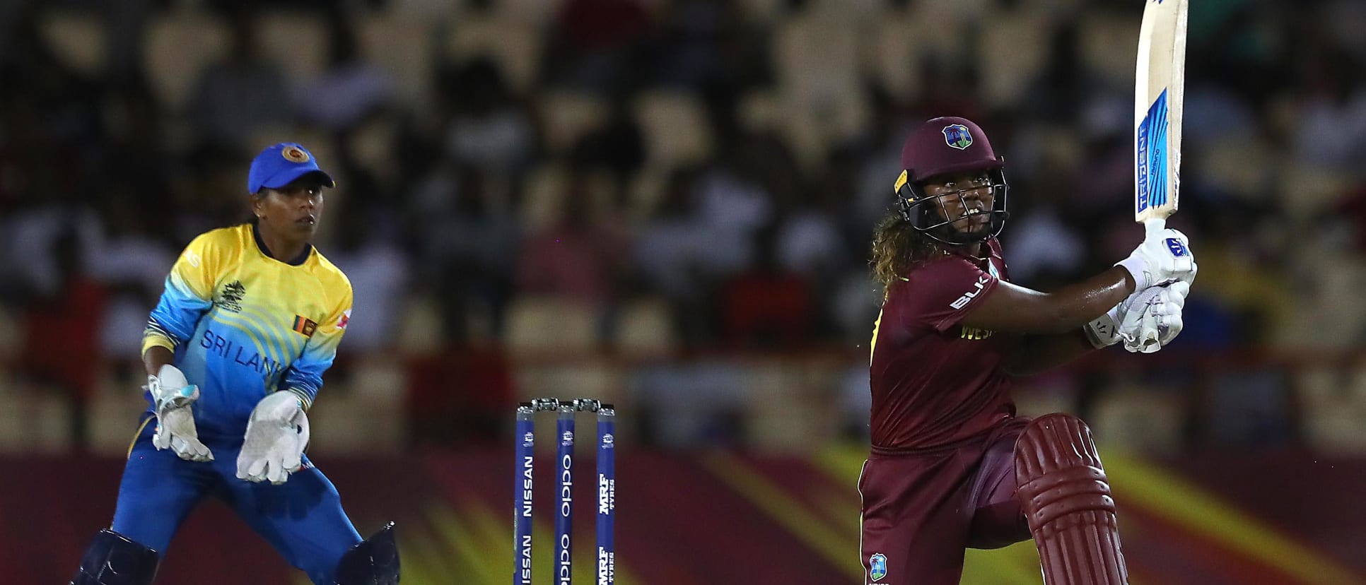 Hayley Matthews of Windies hits the ball towards the boundary, as Dilani Manodara of Sri Lanka looks on during the ICC Women's World T20 2018 match between Windies and Sri Lanka at Darren Sammy Cricket Ground on November 16, 2018