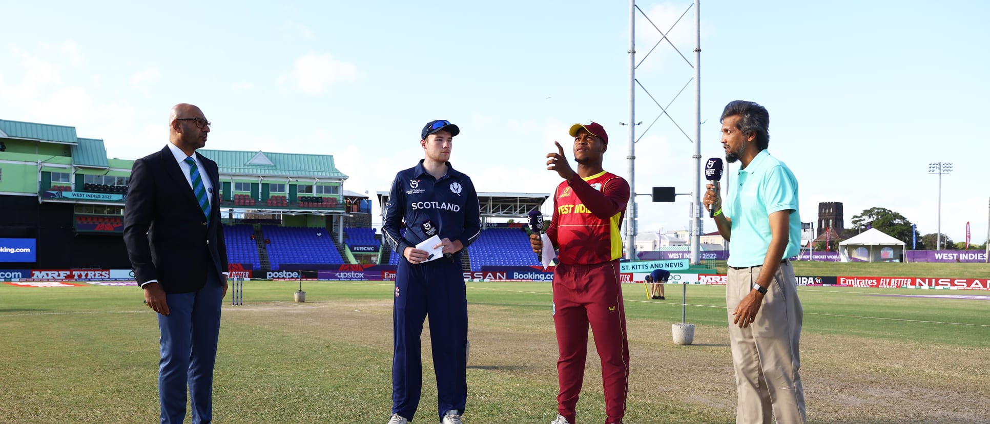 Giovonte Depeiza of West Indies flips the coin as Charlie Peet of Scotland looks on ahead of the ICC U19 Men's Cricket World Cup match between West Indies and Scotland at Warner Park Sporting Complex on January 17, 2022 in Basseterre.